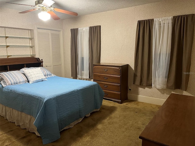 bedroom with ceiling fan, a textured ceiling, a closet, and light carpet