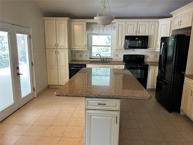 kitchen featuring black appliances, sink, a kitchen island, dark stone counters, and pendant lighting