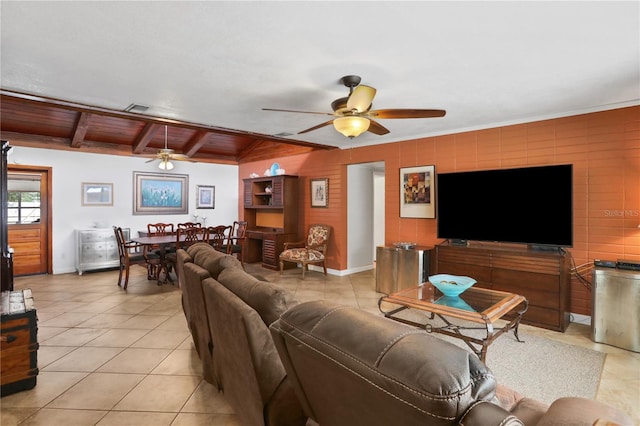 tiled living room with ceiling fan and vaulted ceiling with beams