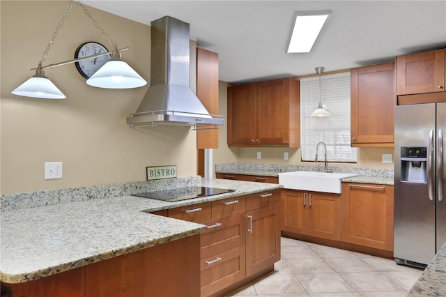 kitchen featuring black electric cooktop, stainless steel fridge, hanging light fixtures, sink, and wall chimney range hood