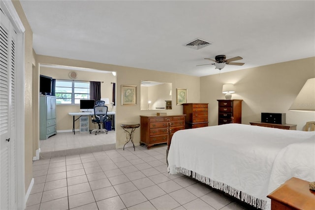 tiled bedroom with ceiling fan and a closet