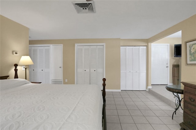 bedroom with light tile patterned flooring and two closets