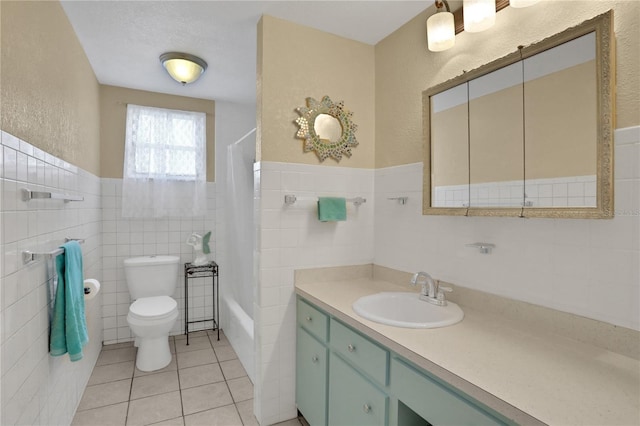 full bathroom featuring tile walls, shower / bath combo with shower curtain, vanity, tile patterned flooring, and toilet