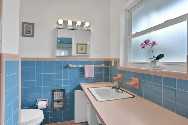 bathroom with vanity, tile walls, and toilet