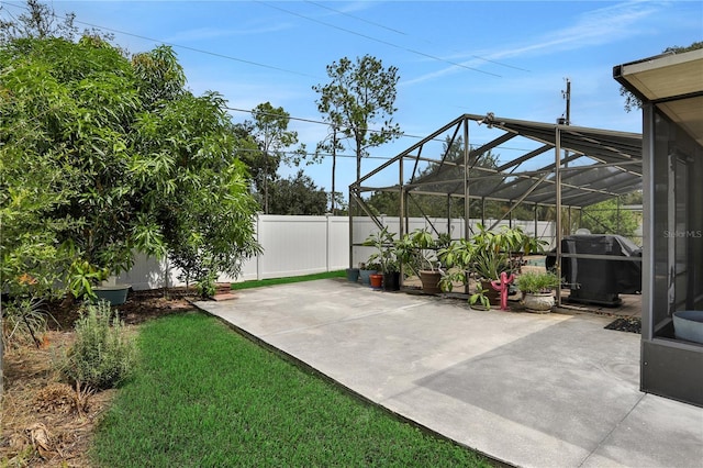 view of patio / terrace with glass enclosure and a grill