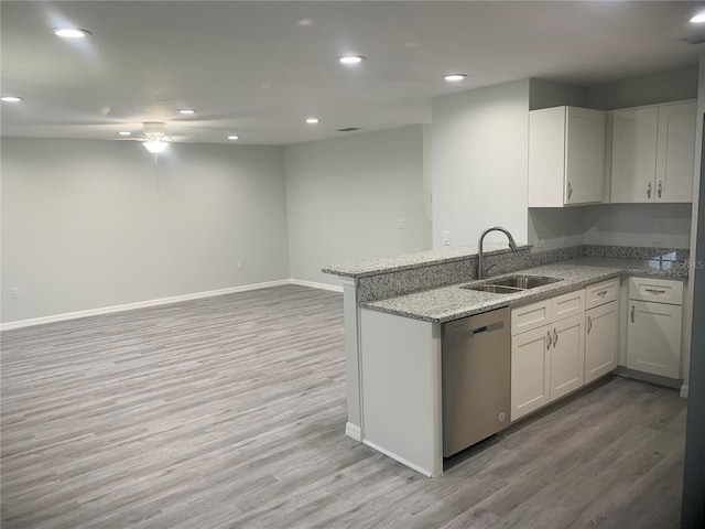 kitchen featuring kitchen peninsula, white cabinets, stainless steel dishwasher, light wood-type flooring, and sink