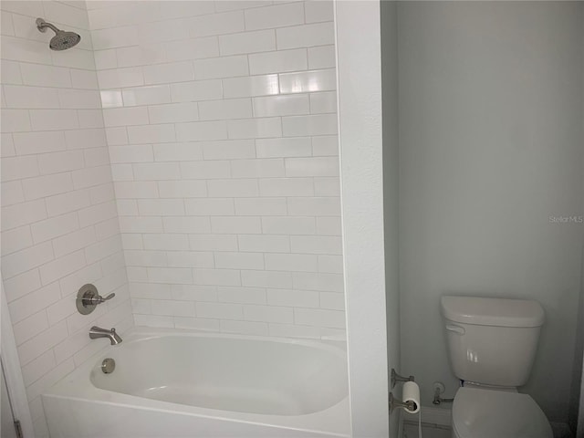 bathroom featuring tiled shower / bath and toilet