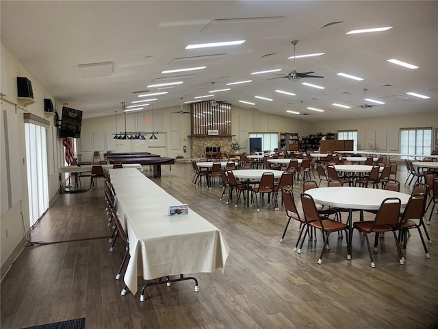 dining space with ceiling fan, wood-type flooring, and vaulted ceiling