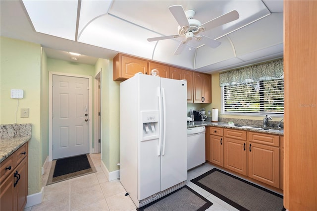 kitchen with light stone counters, ceiling fan, sink, light tile patterned floors, and white appliances