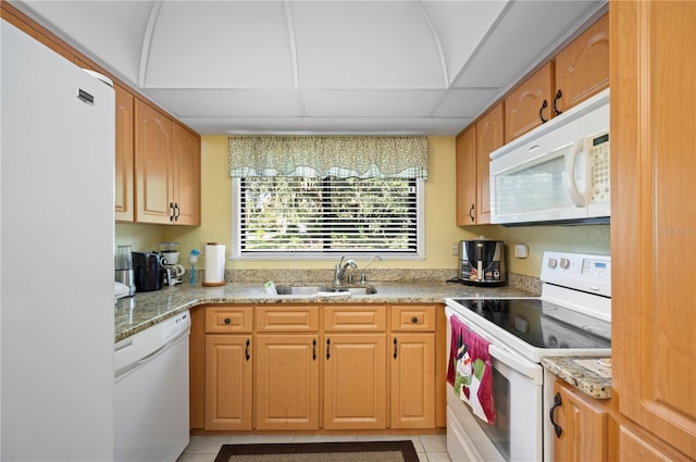 kitchen with light tile patterned floors, sink, white appliances, a paneled ceiling, and light stone countertops