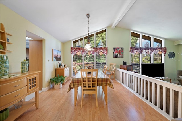 dining area featuring vaulted ceiling with beams and light wood-type flooring