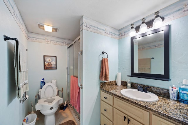 bathroom featuring tile patterned flooring, an enclosed shower, vanity, and toilet