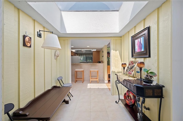 hall featuring a skylight and light tile patterned floors