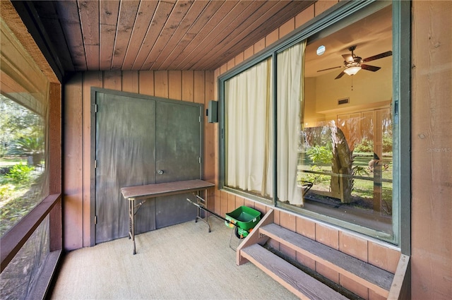 unfurnished sunroom featuring wooden ceiling, vaulted ceiling, ceiling fan, and a wealth of natural light