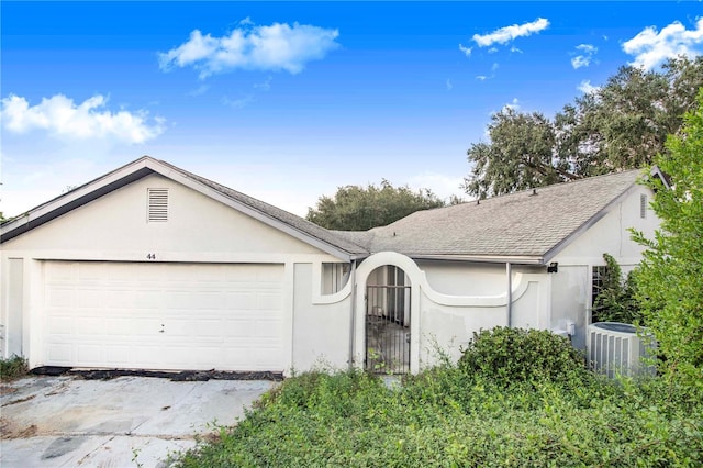 single story home with central AC and a garage