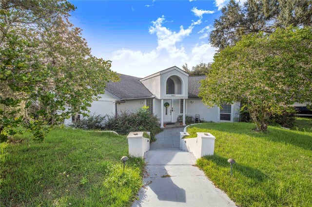 34415 Kingfish St, Fruitland Park, FL 34731 - view of front facade with a front yard, driveway, a shingled roof, and stucco siding