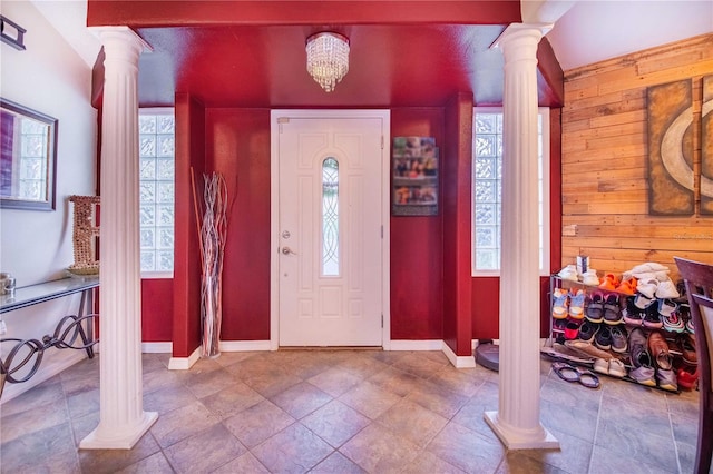 tiled entryway with a chandelier and decorative columns