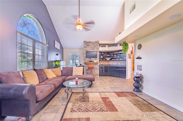 living room featuring high vaulted ceiling, ceiling fan, and light tile patterned floors