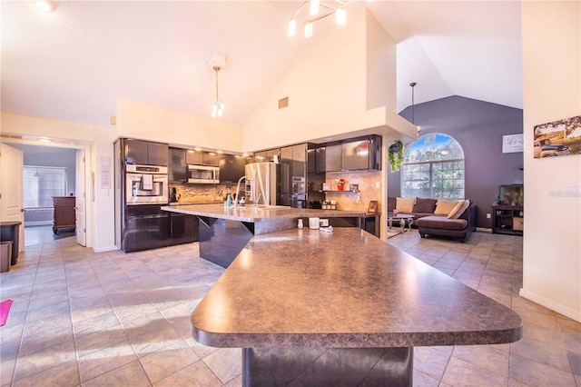 34415 Kingfish St, Fruitland Park, FL 34731 - kitchen featuring appliances with stainless steel finishes, a kitchen bar, a sink, decorative backsplash, and decorative light fixtures