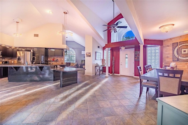 kitchen with tasteful backsplash, decorative light fixtures, a breakfast bar, and stainless steel refrigerator with ice dispenser