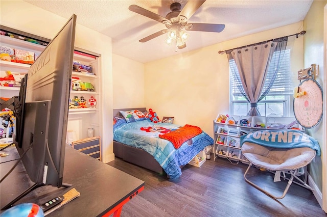 bedroom featuring dark wood-type flooring, a textured ceiling, and ceiling fan