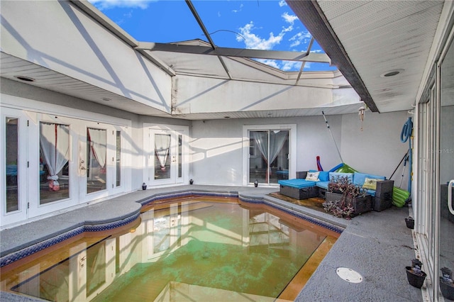 view of pool featuring glass enclosure, french doors, and a patio area