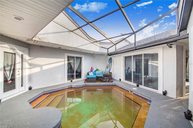 view of swimming pool with glass enclosure and a patio area