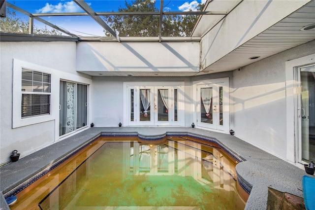 view of swimming pool featuring a lanai and french doors