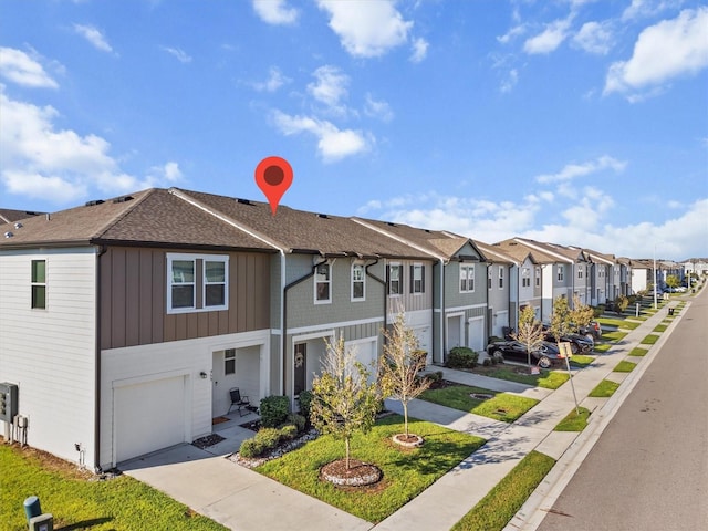 townhome / multi-family property featuring a front yard and a garage