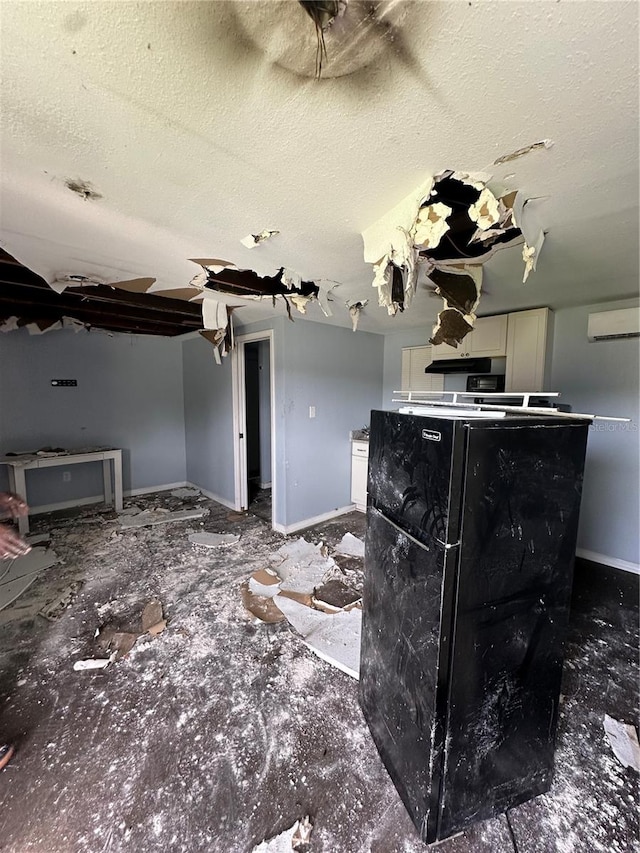 interior space featuring a wall mounted AC and a textured ceiling