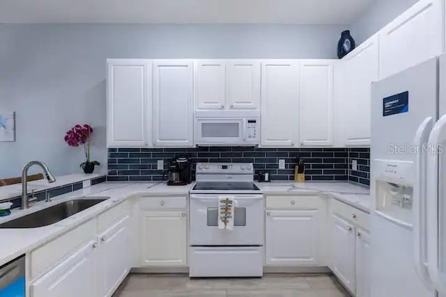 kitchen featuring white appliances, white cabinetry, sink, and tasteful backsplash