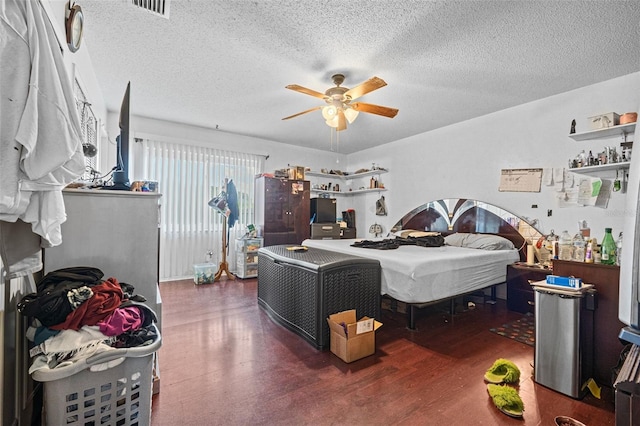 bedroom with a textured ceiling, dark hardwood / wood-style floors, and ceiling fan