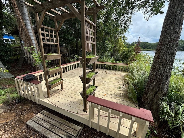 wooden terrace featuring a water view and a pergola