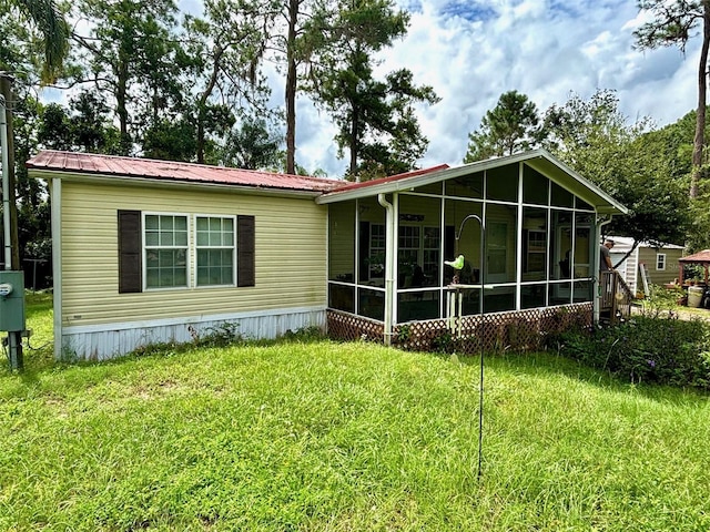 back of property featuring a yard and a sunroom