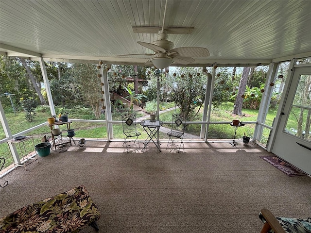 unfurnished sunroom with ceiling fan