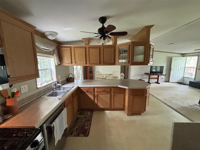 kitchen with kitchen peninsula, stainless steel appliances, sink, light colored carpet, and ceiling fan