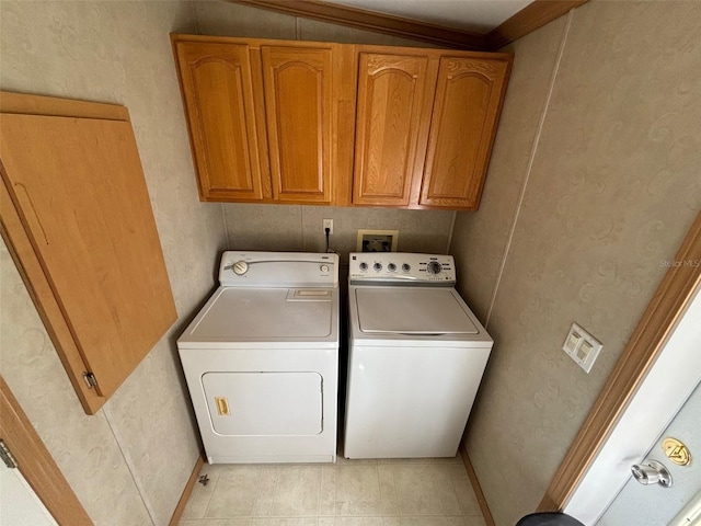 laundry room featuring crown molding, light tile patterned flooring, separate washer and dryer, and cabinets