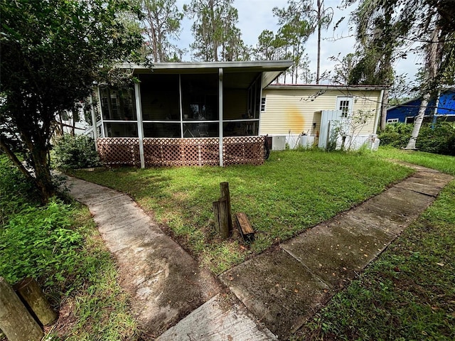 back of property with a yard and a sunroom