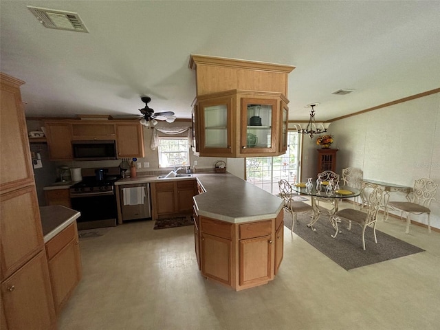 kitchen featuring a kitchen island, stainless steel appliances, ceiling fan with notable chandelier, pendant lighting, and sink