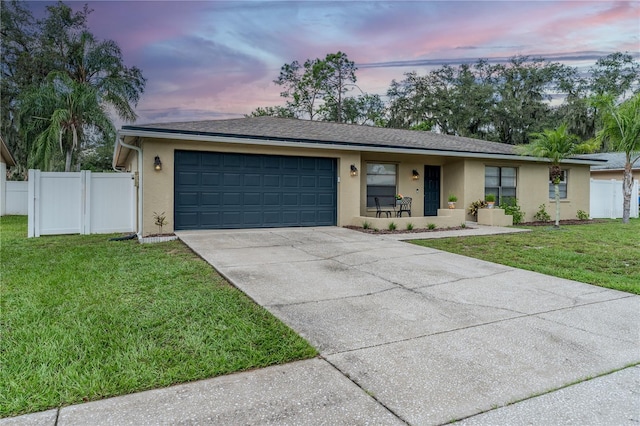 ranch-style home with a lawn and a garage