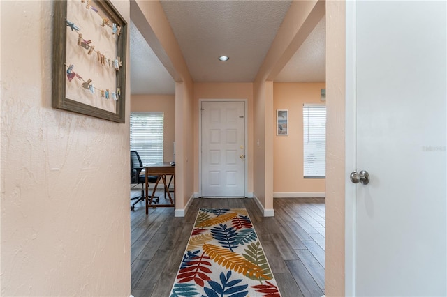 corridor featuring dark hardwood / wood-style floors and a textured ceiling