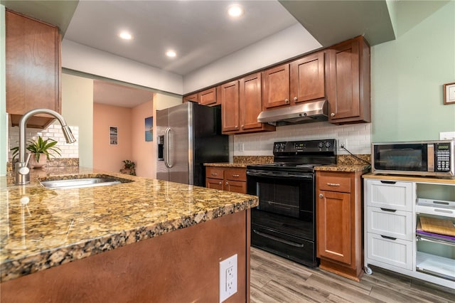 kitchen featuring sink, stainless steel appliances, stone counters, and light hardwood / wood-style flooring