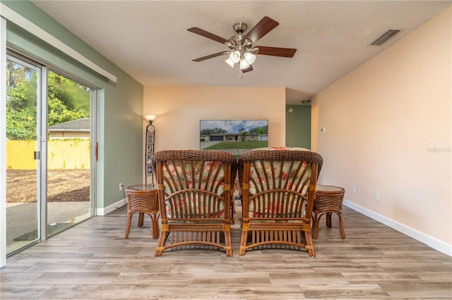 sitting room featuring ceiling fan, a textured ceiling, and light wood-type flooring