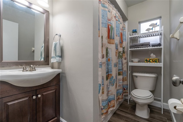 bathroom with toilet, curtained shower, hardwood / wood-style flooring, and vanity