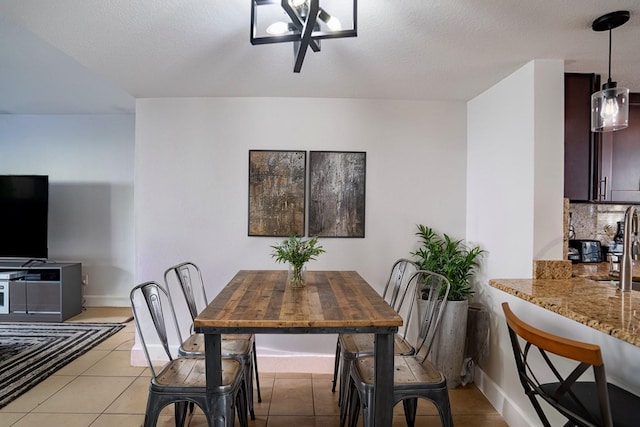 tiled dining area featuring a notable chandelier and a textured ceiling