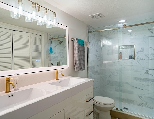 bathroom with vanity, toilet, walk in shower, and a textured ceiling