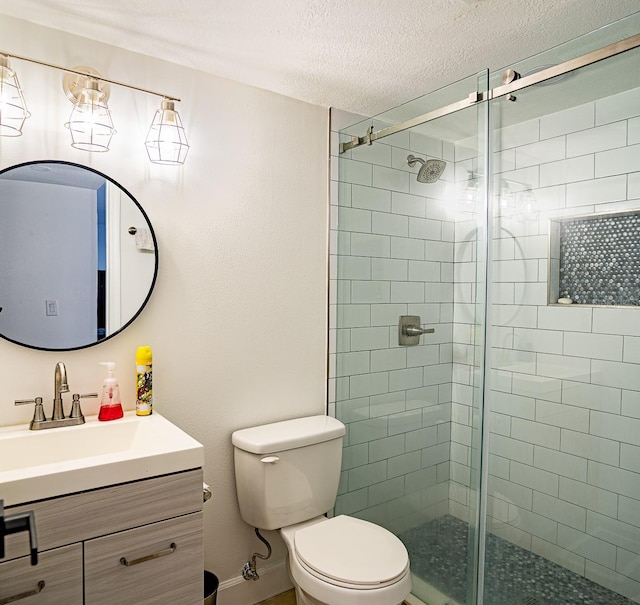 bathroom featuring vanity, toilet, a textured ceiling, and an enclosed shower