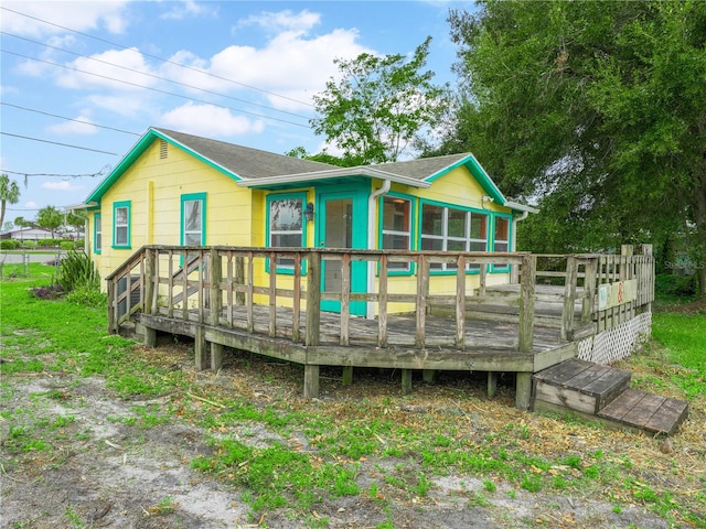 rear view of house with a sunroom and a deck