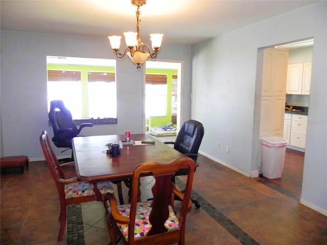 dining space featuring dark tile patterned flooring and a notable chandelier