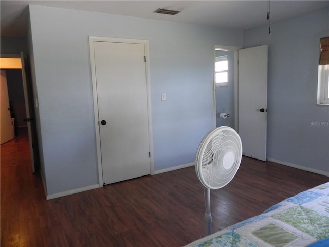 bedroom featuring visible vents, baseboards, and wood finished floors
